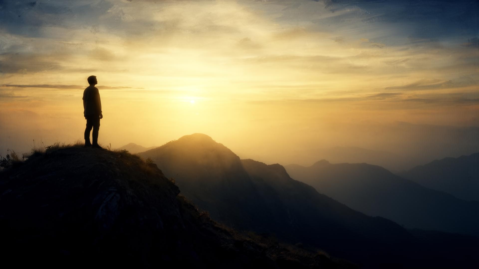 Silhueta olhando para o horizonte ao amanhecer
